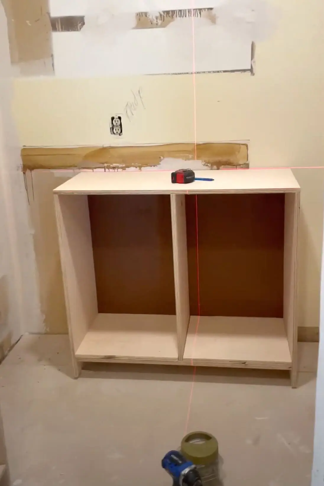 Using a laser level to make sure that my cabinet is level. 